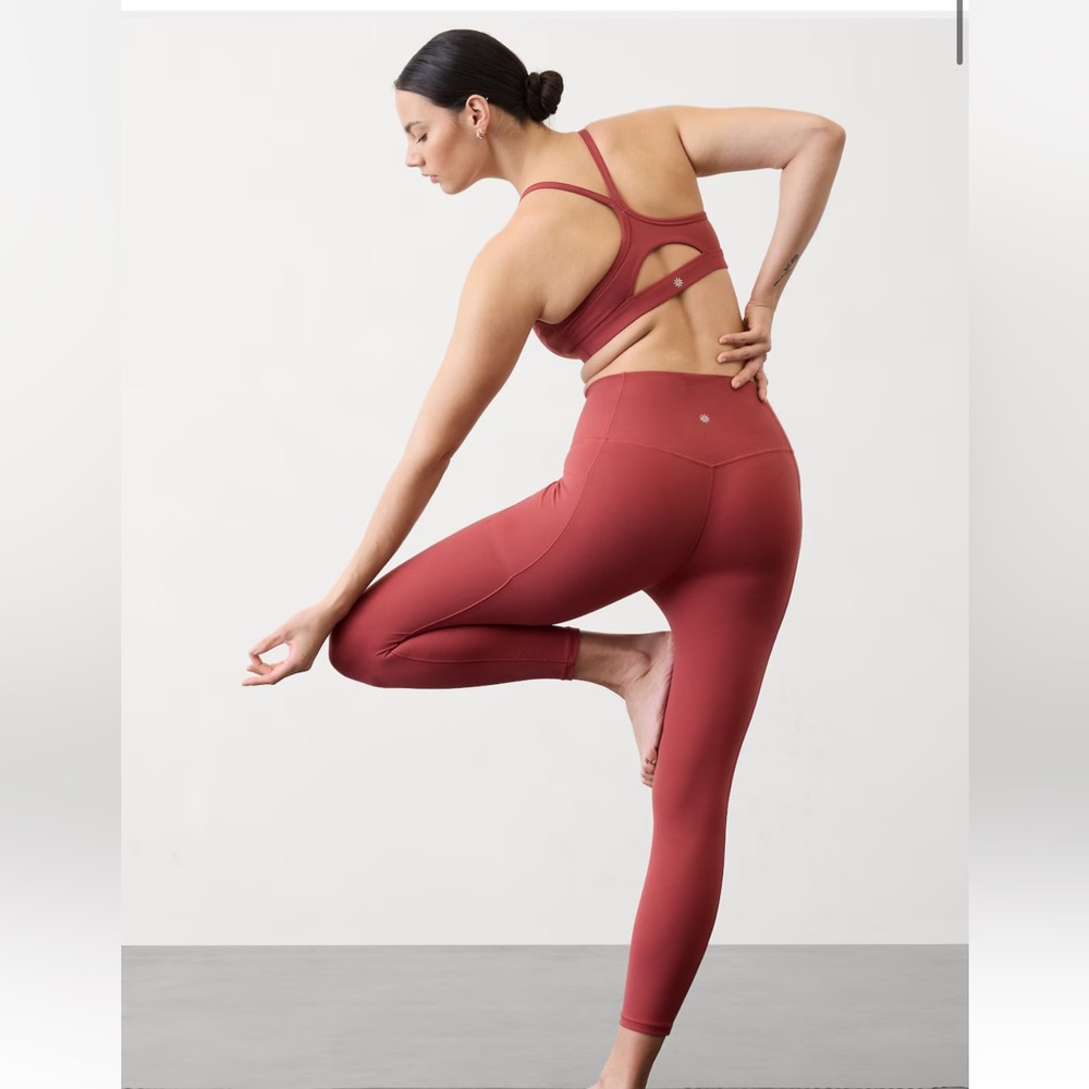 Red/brick color Athleta leggings with side pocket.